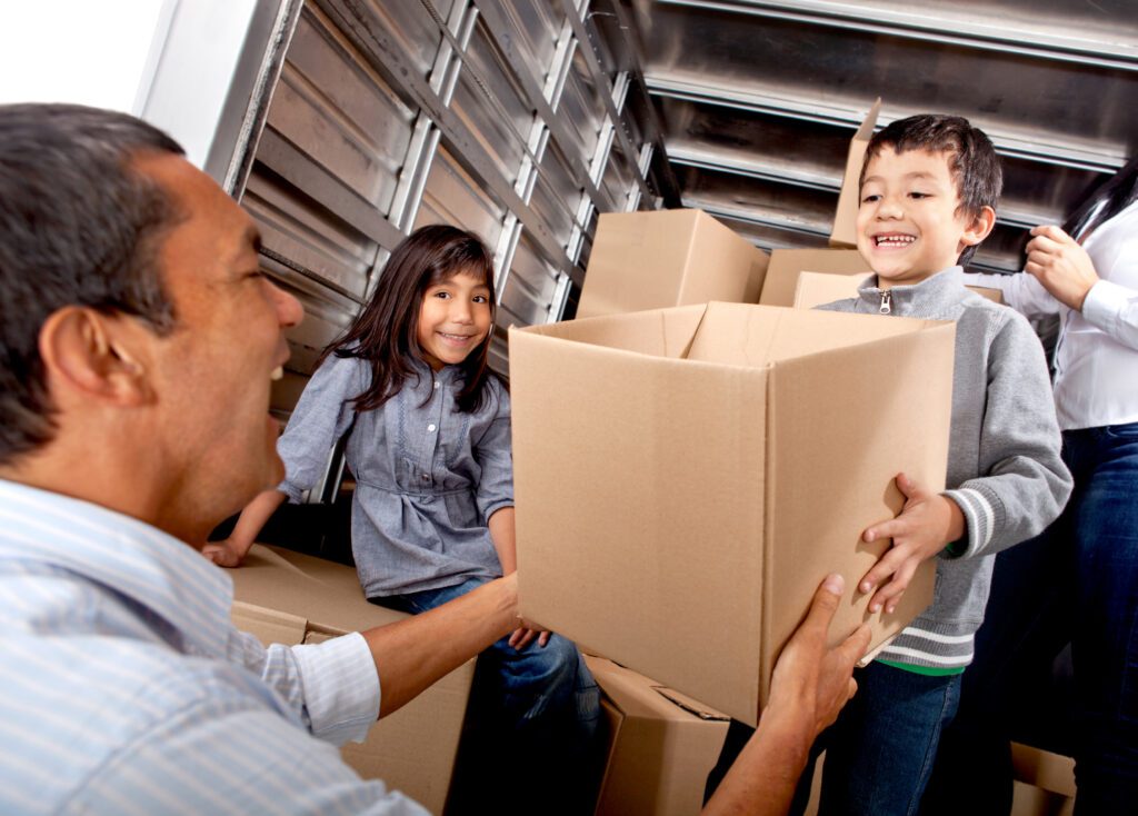 Family organizing boxes inside a self storage unit to show common reasons people use self storage