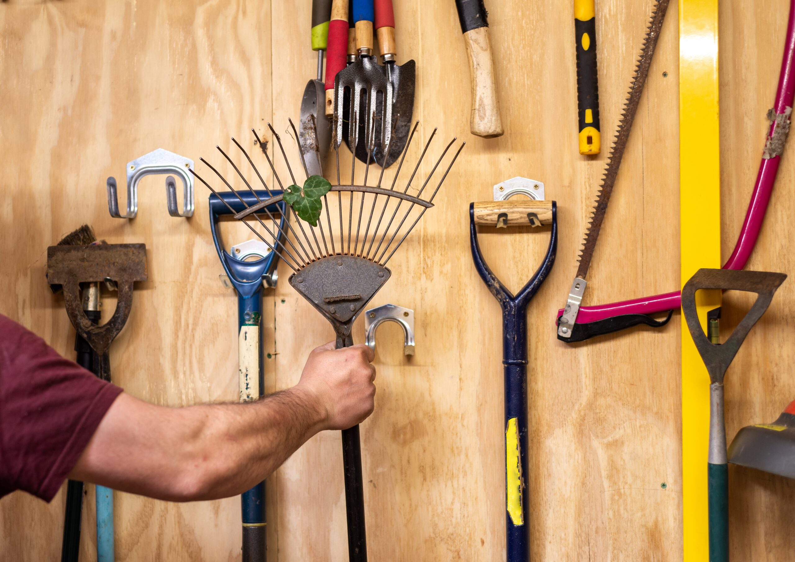 organized outdoor shed with wall hooks, shelving, and labeled bins showing practical shed organization ideas for garden tools and equipment