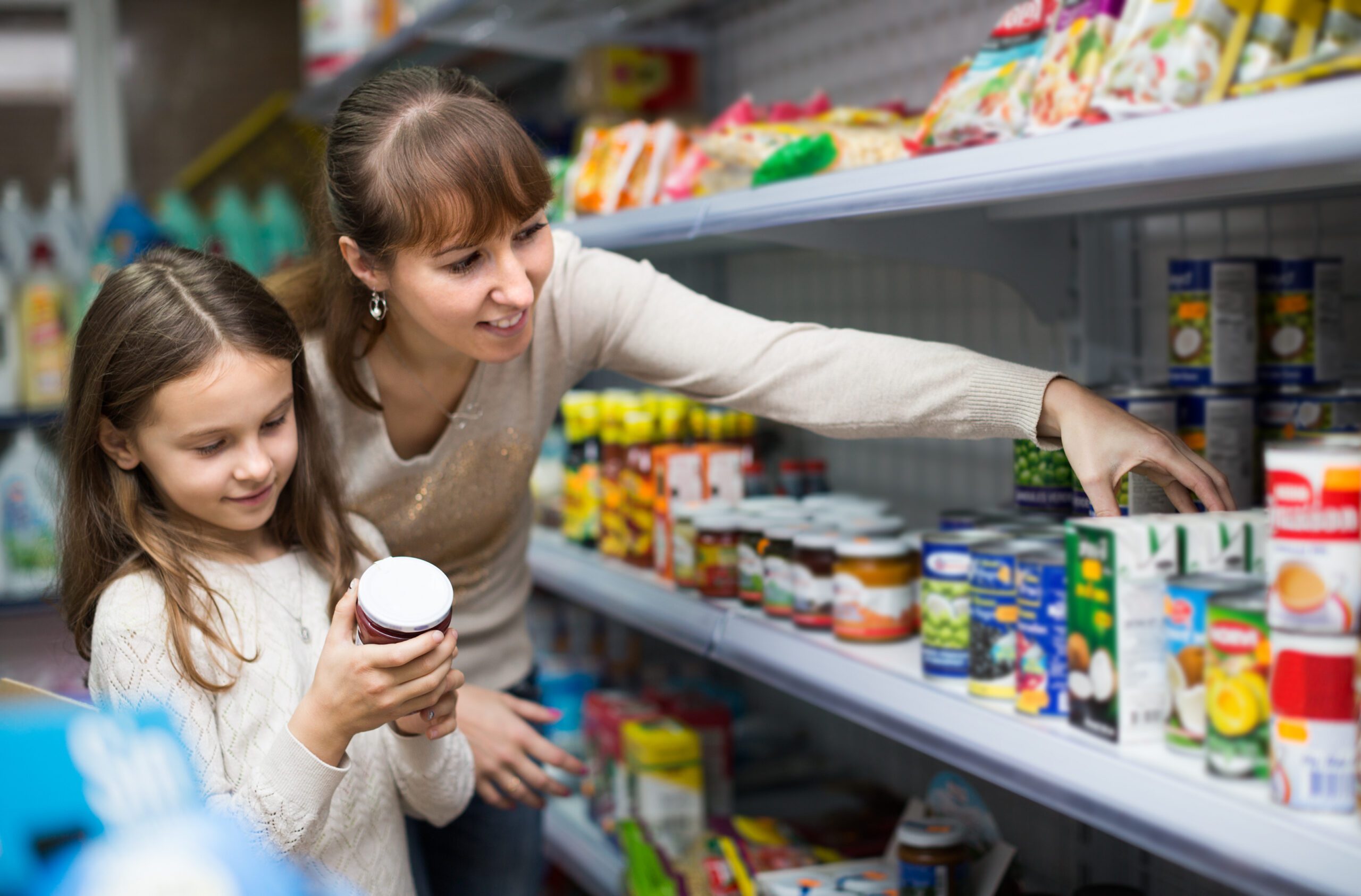 mother with girl buying tinned food